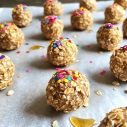 - 1 cup rolled oats - 1/2 cup vanilla protein powder - 1/4 cup almond flour - 1/4 cup almond butter (or any nut/seed butter) - 1/4 cup honey or maple syrup - 1/4 cup unsweetened applesauce - 1 teaspoon vanilla extract - 1/2 teaspoon sprinkles (plus extra for garnish) - Pinch of salt If you have allergies, you can swap some ingredients. For nut allergies, use sunflower seed butter instead of almond butter. If you're allergic to gluten, ensure your oats are certified gluten-free. You can also use a plant-based protein powder for a dairy-free option. Maple syrup works well if you need a vegan sweetener. - Rolled oats provide fiber, which aids digestion and keeps you full. - Vanilla protein powder helps build and repair muscles. - Almond flour is low in carbs and adds healthy fats. - Almond butter gives you protein and vitamin E, which is good for your skin. - Honey or maple syrup adds natural sweetness and has anti-inflammatory properties. - Unsweetened applesauce keeps the bites moist and adds fiber. - Vanilla extract boosts the flavor without extra sugar. - Sprinkles add fun and a touch of joy to your treats. - Salt enhances all the flavors in the recipe. These ingredients come together to make a tasty treat that packs a protein punch. You can enjoy these bites as a snack or a dessert, knowing they are good for you! 1. Grab a large mixing bowl. Add the rolled oats, vanilla protein powder, almond flour, and a pinch of salt. Mix well until combined. 2. In another bowl, blend the almond butter, honey (or maple syrup), unsweetened applesauce, and vanilla extract. Make sure it is smooth and creamy. 3. Pour the wet mix into the dry mix. Stir until fully combined. The mixture should feel sticky. If it seems dry, add a bit more applesauce or honey. 4. Gently fold in the sprinkles. This will add fun color to your bites. 5. Using your hands, roll the mixture into small balls. Aim for about 1-inch in diameter. 6. Place the rolled bites on a parchment-lined baking sheet. Freeze them for around 30 minutes to firm up. 7. Once they are firm, move the bites to an airtight container. Store them in the fridge for up to a week or freeze for longer use. - The mixture should feel sticky but hold together. If it crumbles, add more binding ingredients. - Use fresh almond butter for the best texture. Older nut butters may be too dry. - Check the moisture level in your applesauce. Some brands are drier than others. Adjust accordingly. - Don’t skip the freezing step. This helps the bites hold their shape. - Avoid overmixing when adding sprinkles. This can break them apart and lose color. - Be careful with the amount of sweetener. Too much can make the bites overly sticky. To make the perfect protein bites, keep your hands moist. This helps you roll the mixture easily. If the mix sticks to your fingers, just wet them with a little water. After you roll the bites, place them on a lined baking sheet. Make sure they are not touching. Freeze them for about 30 minutes. After that, they will hold their shape well. If you want, you can store them in an airtight container. This keeps them fresh and tasty for a week in the fridge or longer in the freezer. To make your protein bites even better, try adding some extras. You can mix in different extracts, like almond or coconut. This adds a new layer of flavor. If you love crunch, add some chopped nuts or seeds. These not only taste great but also add texture. For a sweeter bite, toss in a few dark chocolate chips. If you prefer, you can reduce the honey or maple syrup. This can make the bites less sweet for a different taste. These protein bites are great as a snack or a quick breakfast. They pair well with fresh fruit or yogurt for a fun treat. If you want a richer dessert, serve them with a scoop of ice cream. You can also drizzle a little chocolate or caramel sauce on top. For a party, set them out with a colorful plate. Add extra sprinkles for a festive touch. These bites are not just tasty; they are also fun to share! {{image_2}} To make these protein bites vegan, swap the honey for maple syrup. Use a plant-based protein powder instead of vanilla protein powder. Choose almond butter or any nut butter that is vegan. These changes keep the bites tasty and fun. If you need gluten-free bites, use certified gluten-free oats. Almond flour is already gluten-free, so it works well. Make sure your protein powder is gluten-free too. These swaps ensure everyone can enjoy this treat without worry. Want a twist on the classic? Try adding chocolate protein powder instead of vanilla. You can also use cocoa powder for chocolate flavor. For a fruity twist, try almond or coconut extract. These small changes make the bites unique and exciting! To keep your high-protein birthday cake protein bites fresh, use an airtight container. This helps lock in moisture and keeps them from drying out. I recommend placing parchment paper between layers of bites. This way, they do not stick together. Always store them in the fridge or freezer. You can refrigerate or freeze these bites. If you plan to eat them within a week, store them in the fridge. For longer storage, freeze them. Freezing keeps the bites fresh for up to three months. Just be sure to thaw them in the fridge overnight before you enjoy them. In the fridge, these bites last about a week. If you freeze them, they can last up to three months. Always check for any off smell or change in texture before eating. Keeping them properly stored ensures you enjoy every bite! Yes, you can. If you skip the protein powder, use more almond flour. This keeps the texture nice. You might want to add some protein sources, like Greek yogurt or cottage cheese, to keep it balanced. Absolutely! These bites have healthy ingredients. Kids love the taste, especially with the sprinkles. They can be a fun and tasty snack. Just watch for any nut allergies before serving. You can find them in health food stores or online. Look for brands that use quality ingredients. Read the labels to ensure they fit your diet. Local health stores may also have tasty options. If the mixture is sticky, add a bit more almond flour. You can also chill the mix longer before rolling. Keep your hands slightly damp while rolling. This helps the mixture stick less to your hands. Yes! You can use any nut or seed butter you like. Peanut butter, cashew butter, or sunflower seed butter work well. Each will give a different flavor, so feel free to experiment. These high-protein birthday cake protein bites are fun and easy to make. You learned about the best ingredients, how to avoid common mistakes, and tips for great flavor. Remember to store them right for lasting freshness. These bites fit various diets, so everyone can enjoy them. Try these recipes at your next celebration. They’re a tasty treat that packs a protein punch. You’ll feel good knowing you made a healthy choice. Happy baking!