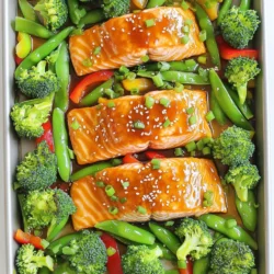 - Salmon fillets: You will need four fresh salmon fillets. They bring rich flavor and omega-3s. - Miso paste and alternatives: Use white miso paste for a mild taste. If you can’t find it, try tahini or peanut butter. - Sweeteners: Honey or maple syrup works well. Honey adds a floral note while maple syrup gives a deeper flavor. - Soy sauce and substitutes: Soy sauce adds umami. If you need a gluten-free option, use tamari or coconut aminos. - Vegetables: Broccoli, snap peas, and red bell pepper add color and crunch. Feel free to mix in your favorite veggies. - Oils and vinegars: Sesame oil enhances the dish. Olive oil and rice vinegar add balanced richness and acidity. - Seasoning essentials: Salt and pepper are a must for flavor. Adjust to taste. - Garnish ideas: Sesame seeds and chopped green onions add a fresh and crunchy finish. They are optional but highly recommended. Each ingredient plays a key role in building flavors. The salmon pairs well with the sweet and savory glaze. The vegetables add texture, making every bite delightful. Start by setting your oven to 400°F (200°C). This will ensure your salmon cooks evenly and quickly. A hot oven helps to caramelize the veggies nicely. In a small bowl, mix the following ingredients: - 3 tablespoons white miso paste - 2 tablespoons honey or maple syrup - 2 tablespoons soy sauce - 1 tablespoon sesame oil - 1 tablespoon rice vinegar - 1 teaspoon grated ginger Whisk these together until smooth. The blend of flavors adds depth to the salmon. Place the 4 salmon fillets in a shallow dish. Pour half the marinade over them. Make sure each fillet is well coated. Let the salmon sit for about 15 minutes. This time helps the flavors soak in. On a large sheet pan, add: - 2 cups broccoli florets - 1 cup snap peas - 1 red bell pepper, sliced Drizzle these with 2 tablespoons of olive oil. Season with salt and pepper. Toss the veggies until they are well coated. This adds flavor and ensures they roast nicely. After marinating, push the veggies to the sides of the pan. Place the salmon fillets in the center. Spoon the remaining marinade over the salmon. This step boosts the flavor even more. Once cooked, remove the pan from the oven. Sprinkle the dish with sesame seeds and chopped green onions. This adds a nice touch of color and crunch. Serve the dish hot, either straight from the pan or plated individually. Enjoy the meal! Marinating is key to great flavor. Use fresh miso paste for the best taste. Mix the marinade well. Make sure all the ingredients blend smoothly. Coat the salmon well. Let it marinate for at least 15 minutes. This allows the salmon to absorb all the rich flavors. If you have time, marinate for up to an hour. Longer marinating gives even deeper flavor. Ovens can cook differently. If you have a convection oven, reduce the cooking time by about 5 minutes. Convection ovens cook faster due to the airflow. For standard ovens, stick to the 15-20 minute range. Always check the salmon with a fork. It should flake easily when done. If you have an older oven, you might need a few extra minutes. Keep an eye on the veggies too; they should be tender but still crisp. To get perfectly cooked salmon, aim for a bright pink center. It should not appear raw. Use a thermometer if you want accuracy. The salmon should reach an internal temperature of 145°F (63°C). For veggies, cut them evenly to ensure they cook at the same rate. Broccoli and snap peas should stay vibrant. A little bite in them is perfect. If you want extra crunch, add the veggies halfway through cooking. Presentation makes a dish shine. You can serve directly from the sheet pan for a rustic look. This is easy and fun for family meals. For a more elegant touch, plate each salmon fillet individually. Drizzle extra marinade over the top. Add a sprinkle of sesame seeds and green onions for color. Use fresh herbs like cilantro or parsley for a pop of green. This adds flavor and makes the dish look professional. {{image_2}} Feel free to change the veggies in this dish. For a colorful mix, try carrots, zucchini, or asparagus. Each veggie adds its own flavor and texture. Have fun experimenting! You can roast eggplant or use Brussels sprouts for a unique twist. Just remember to cut them into even sizes for even cooking. You can switch the marinade for different tastes. Try using tahini instead of miso for a nutty flavor. If you want it spicy, add a teaspoon of sriracha or chili paste. For a citrus kick, mix in some orange or lime juice. These small changes can make your dish stand out. Serve your salmon and veggies over a bed of grains. Quinoa, brown rice, or farro work great. These grains soak up the sauce and add heartiness. You can also pair it with a fresh salad or a side of roasted sweet potatoes. This adds more nutrition and makes your meal even more satisfying. After enjoying your sheet-pan miso glazed salmon and veggies, let the leftovers cool. Place them in an airtight container. Make sure to separate the salmon from the veggies to keep them fresh. Store them in the fridge for up to three days. This way, you can easily reheat them later. To reheat, use an oven for the best taste. Preheat your oven to 350°F (175°C). Place the salmon and veggies on a baking sheet. Cover them with foil to keep moisture in. Heat for about 10-15 minutes until warm. You can also use a microwave. Just cover the dish and heat for 1-2 minutes. Check that it’s warm all the way through. If you want to save some for later, freezing works well. Wrap each salmon fillet tightly in plastic wrap. Then, place them in a freezer bag or container. For the veggies, use an airtight container. They can stay frozen for up to two months. When you’re ready to eat, thaw them in the fridge overnight before reheating. Yes, you can use frozen salmon. Just thaw it first. Place it in the fridge overnight. You can also use the cold water method. Seal the salmon in a bag and submerge it in cold water for about an hour. Once thawed, proceed with the recipe as planned. If you don't have miso paste, you can use tahini. Mix it with a bit of soy sauce for a similar taste. Another option is to blend peanut butter with soy sauce and a splash of vinegar. This will give you a nice, creamy sauce. To add spice, include some sriracha or chili paste in the marinade. You can also sprinkle red pepper flakes over the salmon and veggies before baking. For a fresh kick, add sliced jalapeños on top. Adjust the level of heat to your liking. Yes, this recipe is great for meal prep! You can make it ahead and store it in containers. Just reheat in the microwave or oven when ready to eat. It holds up well and keeps flavors intact, making it a smart choice for busy weeks. The dish is good for about 3 to 4 days in the fridge. Make sure to store it in an airtight container. If you want to keep it longer, consider freezing it. Just note that the texture may change once thawed. In this post, we explored a tasty salmon dish that you can make at home. We covered the essential ingredients, cooking steps, and useful tips to perfect your meal. Remember, you can switch up vegetables or marinate with different flavors. This dish is not only simple but also a healthy option for any table. Enjoy your cooking and don't hesitate to try new ideas. Cooking is fun, and every meal can be unique!