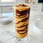 To make the Chocolate Peanut Butter Pumpkin Protein Smoothie, gather these simple ingredients. Each one plays a key role in making this drink tasty and healthy. - 1 cup unsweetened almond milk - 1 ripe banana - 1/2 cup pumpkin puree - 2 tablespoons natural peanut butter - 2 tablespoons cocoa powder - 1 scoop chocolate protein powder - 1 tablespoon maple syrup (optional) - 1/2 teaspoon cinnamon - 1/4 teaspoon nutmeg - Ice cubes (optional) Using unsweetened almond milk keeps this smoothie light. A ripe banana adds natural sweetness and creaminess. Pumpkin puree is full of fiber and gives a nice fall flavor. Natural peanut butter adds protein and richness without added sugars. Cocoa powder gives that chocolatey taste you love. The chocolate protein powder boosts the smoothie’s protein content, making it great for recovery. Maple syrup is optional for extra sweetness, but the banana usually does the job. Cinnamon and nutmeg add warmth and spice to every sip. If you like thicker smoothies, toss in some ice cubes. The best part is that you can mix and match these ingredients based on your taste. Get ready to enjoy a delicious and nutritious treat! - Step 1: Combining Ingredients Start by pouring 1 cup of unsweetened almond milk into your blender. Then, add 1 ripe banana, 1/2 cup of pumpkin puree, and 2 tablespoons of natural peanut butter. These ingredients blend well and create a creamy base. - Step 2: Adding Flavor Enhancers Next, sprinkle in 2 tablespoons of cocoa powder and 1 scoop of chocolate protein powder. Add 1/2 teaspoon of cinnamon and 1/4 teaspoon of nutmeg for warmth and spice. If you like it sweeter, add 1 tablespoon of maple syrup. - Step 3: Blending to Perfection Blend all the ingredients on high speed until you achieve a smooth and creamy texture. If you want a colder and thicker smoothie, toss in a handful of ice cubes before blending. - Step 4: Adjusting Sweetness After blending, taste your smoothie. If you find it needs more sweetness, add more maple syrup. Blend briefly to mix in the syrup. This step is key for a balanced flavor. - Step 5: Serving Suggestions Pour the smoothie into a tall glass or bowl. You can top it with a sprinkle of cinnamon or a dollop of peanut butter for extra flair. This smoothie is perfect for breakfast or a healthy snack. Enjoy! Choosing the Right Ingredients To make the best Chocolate Peanut Butter Pumpkin Protein Smoothie, pick ripe fruit. A ripe banana adds natural sweetness and creaminess. Use unsweetened almond milk for a light base. Pumpkin puree gives a rich texture and is packed with nutrients. Select natural peanut butter for a pure flavor. Cocoa powder adds depth and a chocolatey taste. Blending Techniques for Smooth Texture Start by adding liquids first when blending. This helps the blender mix the ingredients smoothly. Then, add the banana, pumpkin, and peanut butter. Next, sprinkle in the cocoa powder and protein powder. Blend on high until the mixture is completely smooth. If it's too thick, add a bit more almond milk. For a colder drink, toss in ice cubes and blend again. Storing Leftovers Safely If you have extra smoothie left, store it in an airtight container. Place it in the fridge and drink it within 24 hours. Smoothies can separate as they sit. Just shake or stir well before drinking. If you want to keep it longer, you can freeze it in ice cube trays. Then, blend the cubes later for a quick treat! {{image_2}} You can make this smoothie suit your needs. Here are some easy swaps: - Dairy Alternatives for a Vegan Option: Use oat milk or soy milk instead of almond milk. Both options work great and keep it dairy-free. - Sweetener Options Beyond Maple Syrup: If you want to try something new, use honey or agave syrup. Both add sweetness. - Adding Greens for Nutritional Boost: Toss in a handful of spinach or kale. It adds nutrients without changing the taste. You can enjoy this smoothie all year. Here are some fun ideas for each season: - Fall-Inspired Additions: Add a pinch of cloves or ginger for a warm flavor. You could also mix in some chopped apples. This gives a nice fall twist. - Summer Refreshers: Blend in some frozen berries or pineapple. These fruits make the smoothie light and refreshing, perfect for hot days. After you make your Chocolate Peanut Butter Pumpkin Protein Smoothie, you may have some leftovers. Storing them right keeps them fresh and tasty. - Refrigeration Tips: Pour any leftover smoothie into a clean, airtight container. Seal it well to keep air out. It stays fresh in the fridge for up to 24 hours. When you're ready to drink it, give it a quick shake or stir. This helps mix it up again. - Freezing the Smoothie: If you want to save it longer, freeze the smoothie. Use ice cube trays or freezer-safe bags. Pour the smoothie into the tray and freeze until solid. This way, you can grab a cube or two later for a quick treat. Blend frozen cubes with a splash of almond milk for a quick smoothie fix. Knowing how long your smoothie lasts is key to enjoying it at its best. - Shelf Life and Signs of Spoilage: In the fridge, your smoothie lasts about 24 hours. After that, it may start to separate or develop an off smell. If it smells sour or looks weird, it’s best to toss it. In the freezer, it can last for up to three months. Just remember to check for icy crystals or freezer burn. These can change the taste. Enjoy your smoothie while it’s fresh for the best flavor and nutrition! Can I make this smoothie ahead of time? Yes, you can make this smoothie ahead of time. Just blend and store it in the fridge. It tastes best fresh, but it will keep for up to 24 hours. Shake or stir it well before drinking. Is it possible to use other types of protein powder? Absolutely! You can use any protein powder you like. Plant-based, whey, or casein all work. Just remember that different powders might change the taste a bit. Can I add more vegetables to this smoothie? Yes, you can add more veggies! Spinach or kale blends well without changing the taste. They add fiber and nutrients without overpowering the chocolate or pumpkin flavors. What are the health benefits of the ingredients used? This smoothie is packed with benefits: - Pumpkin puree adds vitamins A and C. - Peanut butter provides healthy fats and protein. - Bananas offer potassium and energy. - Cocoa powder is rich in antioxidants. - Almond milk is low in calories and dairy-free. These ingredients make this smoothie a tasty and healthy choice. You learned how to make a tasty and healthy smoothie. We covered ingredients, step-by-step prep, tips, and fun variations. Remember to use fresh ingredients and store any leftovers properly. A good smoothie can fit any meal or snack time. Enjoy experimenting with flavors and ingredients. Your smoothie journey has just begun. Keep blending and tasting!