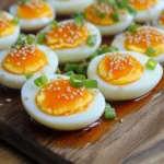 To make Spicy Sriracha Ramen Eggs, you need a few simple items. Here’s the list: - 4 large eggs - 2 tablespoons soy sauce - 1 tablespoon rice vinegar - 1 tablespoon Sriracha (adjust to taste) - 1 teaspoon sesame oil - 1 teaspoon sugar - 1 green onion, finely sliced (for garnish) - Toasted sesame seeds (for garnish) These ingredients come together to create a tasty and spicy treat. The eggs provide a great texture, while the Sriracha adds heat. The soy sauce gives depth, and the vinegar balances it all out. Sesame oil adds a nice nutty flavor. I love how these ingredients work together to elevate the humble egg! To start, bring a medium pot of water to a boil. Gently add 4 large eggs. Boil them for 6-7 minutes for soft-boiled eggs. If you want firmer yolks, add a minute or two to the boiling time. After boiling, you need to cool the eggs fast. Transfer them right away to a bowl of ice water. This ice bath stops the cooking and helps keep the yolks soft. Let them cool for about 5-10 minutes. Once the eggs are cool, it’s time to peel them. To make peeling easy, gently tap the eggs on a hard surface. Roll them slightly to crack the shell. Start peeling from the wider end, where the air pocket is. Set the peeled eggs aside. Now, let’s mix the marinade. In a bowl, combine: - 2 tablespoons soy sauce - 1 tablespoon rice vinegar - 1 tablespoon Sriracha (adjust this to your spice level) - 1 teaspoon sesame oil - 1 teaspoon sugar Stir these ingredients until the sugar dissolves completely. Place the peeled eggs in a shallow container or a resealable bag. Pour the marinade over them. Make sure the eggs are fully submerged. For the best flavor, let them marinate in the fridge for at least 2 hours, or overnight if you want a stronger taste. When you’re ready to enjoy your spicy ramen eggs, take them out of the marinade. Slice each egg in half. For a pretty touch, sprinkle with finely sliced green onions and toasted sesame seeds. This adds crunch and flavor to your dish. To change how spicy your ramen eggs are, you can adjust the amount of Sriracha. Start with one tablespoon, then taste the marinade. If you want more heat, add more Sriracha, one teaspoon at a time. This way, you can find the right balance that suits your taste. Boiling eggs can be tricky. To avoid cracks while boiling, gently place the eggs in the pot. Use room temperature eggs instead of cold ones. You can also add a pinch of salt or vinegar to the water. This helps keep the eggs intact during cooking. You can make your marinade even better by adding more ingredients. Try adding garlic or ginger for extra depth. You can also mix in a splash of lime juice or a bit of chili oil for a unique twist. Experiment and find what flavors you love most! {{image_2}} Try different hot sauces to change the taste. You can use chili garlic sauce for a punch. If you like sweet heat, try a honey sriracha mix. For a smoky flavor, consider chipotle sauce. Each option brings a unique twist to your ramen eggs. You can add eggs to many ramen dishes. They enhance the meal, making it richer. Try using them with chicken or pork ramen. You can also mix in tofu for a different texture. Eggs boost both the flavor and protein content of any bowl. If you want a non-spicy version, swap Sriracha for a mild sauce. Try using hoisin sauce for sweetness without heat. You can also use soy sauce alone for a classic taste. This way, even non-spicy eaters can enjoy these tasty eggs. Store your marinated eggs in airtight containers. Glass or plastic containers work well. You can also use resealable bags. Make sure to remove as much air as possible when sealing bags. This keeps the eggs fresh and flavorful. Marinated eggs can last up to one week in the fridge. If you want the best taste, eat them within three to five days. Always check for any off smells before eating. If they smell bad, it's best to throw them away. Freezing ramen eggs is an option, but it may change their texture. If you choose to freeze them, crack the eggs open and marinate the whites. Avoid freezing the yolks, as they can become grainy. Place the whites in a freezer-safe container and label them. Use them within two months for the best taste. When ready to enjoy, thaw them in the fridge overnight. The best marination time for ramen eggs is at least 2 hours. This time lets the eggs soak up all the flavors. For a stronger taste, you can marinate them overnight. The longer they sit, the deeper the flavor gets. You can check them after a couple of hours to see if you like the taste. Yes, you can use eggs from the pantry. Just make sure they are fresh. Room temperature eggs are safe to use if they are not past their expiration date. If you have any doubts, do a quick water test. Place the egg in water; if it sinks, it’s fresh. If it floats, it’s best to toss it. If you want to skip Sriracha, you can use soy sauce and rice vinegar. Add a bit of chili oil for some heat. Another option is to use a bit of garlic or ginger for flavor. You can also mix in some honey for a sweet touch. This way, you still get tasty ramen eggs without the spice. This post shared how to make tasty ramen eggs. You learned about key ingredients, step-by-step instructions, and tips for success. We explored storage, variations, and answered common questions. Remember, marinating is key to flavor. Experiment with different sauces and spiciness levels to find what you like best. Making these eggs can elevate your ramen and impress your friends. Try it yourself and enjoy the rich taste and fun texture!