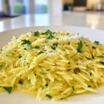 To make Minute Herb Butter Orzo, you need just a few key ingredients: - 1 cup orzo pasta - 2 tablespoons unsalted butter - 3 cloves garlic, minced - 1 tablespoon fresh lemon juice - 1 teaspoon lemon zest - 1 tablespoon fresh parsley, chopped - 1 tablespoon fresh basil, chopped - Salt and pepper to taste These ingredients combine to create a rich and tasty dish. The orzo pasta serves as the base. The butter brings in a creamy feel, while garlic adds a savory punch. Lemon juice and zest give it a bright, fresh taste. Finally, the parsley and basil provide a lovely herb flavor. While the essential ingredients make a great dish, a few optional items can make it even better: - ¼ cup grated Parmesan cheese (optional) Adding Parmesan gives a nice, salty depth to the dish. If you love cheese, sprinkle it in. You can also try adding a pinch of red pepper flakes for some heat or a splash of white wine for a touch of acidity. Choosing fresh herbs and good cheese will enhance your orzo. Here are some tips: - Fresh Herbs: Look for vibrant green leaves. They should smell strong and fresh. Avoid any wilted or brown parts. - Quality Parmesan: Choose a wedge instead of pre-grated cheese. Freshly grated Parmesan has better flavor and texture. Check for a nutty aroma and a slightly crumbly texture. By picking quality ingredients, your Minute Herb Butter Orzo will shine on your table! First, fill a medium pot with 4 cups of salted water. Place it over high heat and bring it to a boil. Once the water is boiling, add 1 cup of orzo pasta. Cook the orzo according to the package instructions, usually about 8 to 10 minutes. You want it to be al dente, which means it should be firm but not hard. When it’s done, drain the orzo well. Set it aside for now. While the orzo cooks, grab a large skillet. Heat it over medium heat and add 2 tablespoons of unsalted butter. Wait for the butter to melt completely. Once melted, toss in 3 cloves of minced garlic. Sauté the garlic for about 1 minute. Stir it often, so it doesn’t brown. You want it to smell amazing, but not burnt. Now, it’s time to combine everything. Take the drained orzo and add it to the skillet with the garlic butter. Next, pour in 1 tablespoon of fresh lemon juice and add 1 teaspoon of lemon zest. Toss in 1 tablespoon each of chopped parsley and basil. Stir everything together until the orzo is well coated in the herb butter. Season with salt and pepper to taste. If you like, sprinkle in ¼ cup of grated Parmesan cheese. Stir until the cheese melts and blends in. Let it sit for a minute to let the flavors mix. Enjoy your Minute Herb Butter Orzo! To make perfect orzo, start with salted water. Bring 4 cups of water to a boil. Add 1 cup of orzo pasta. Follow the package instructions. It usually takes 8 to 10 minutes. Check the orzo a minute early. You want it firm but not hard. This texture is called al dente. Drain the orzo well before mixing it with the butter and garlic. Use a large skillet for melting butter. Set your heat to medium. Add 2 tablespoons of unsalted butter. Wait until the butter melts fully. This should take about a minute. Add 3 minced garlic cloves. Stir the garlic for about 1 minute. Keep an eye on it, so it doesn’t turn brown. Brown garlic can taste bitter. You want it fragrant and golden. To boost flavor, add fresh herbs. I love using parsley and basil. Use 1 tablespoon of each, chopped finely. Lemon juice adds brightness, too. Use 1 tablespoon of fresh lemon juice and 1 teaspoon of lemon zest. For a cheesy kick, add ¼ cup of grated Parmesan cheese. Adjust salt and pepper to taste. These will make your orzo pop with flavor! {{image_2}} You can easily boost the nutrition of Minute Herb Butter Orzo. Try adding vegetables. Some great options are spinach, peas, or cherry tomatoes. Just sauté them in the skillet before adding the orzo. Cook them until they are tender, around three to four minutes. This adds color and a healthy crunch to your dish. If you want more protein, add chicken or shrimp. For chicken, use cooked, shredded pieces. Stir them in after mixing the orzo with the herb butter. For shrimp, sauté them in the skillet until they turn pink. This takes about two to three minutes. Both options make your orzo more filling and satisfying. For a gluten-free version, use rice or quinoa. Both options work well with the herb butter and lemon flavors. Cook them according to package directions, just like you would with orzo. This way, you can still enjoy the dish without gluten. To store leftover Minute Herb Butter Orzo, let it cool first. Then, place it in an airtight container. Make sure to seal it well. You can keep it in the fridge for up to three days. This keeps the flavors fresh and the texture nice. When you reheat the orzo, add a splash of water. This helps keep it moist. Use a skillet over low heat or the microwave. If using the microwave, cover it to trap steam. Stir it often to heat evenly. This way, the orzo stays creamy and tasty. To freeze Minute Herb Butter Orzo, pack it in a freezer-safe container. Leave some space at the top for expansion. It will last for up to three months in the freezer. When you are ready to eat, thaw it in the fridge overnight. Reheat it using the tips above for best results. Yes, you can use other pasta shapes. Try small pasta like ditalini or acini di pepe. These shapes cook well and pair nicely with the herb butter. Just follow their cooking times on the package. To make this dish vegan, swap the butter for plant-based butter. You can also skip the Parmesan cheese or use a vegan cheese alternative. The lemon and herbs will still shine in this dish. Minute Herb Butter Orzo pairs well with many foods. Serve it alongside grilled chicken or fish for protein. You can also add a fresh salad or roasted vegetables for a balanced meal. This dish works great as a side or a main. Minute Herb Butter Orzo is simple yet full of flavor. We explored essential and optional ingredients to enhance your dish. I provided clear steps for preparing this tasty meal and shared tips for cooking orzo to perfection. You can also add veggies or protein for a nutritious twist. Remember to store leftovers properly to enjoy later. With this guide, you can create a delicious orzo dish that suits your taste. Enjoy cooking and experimenting with flavors!